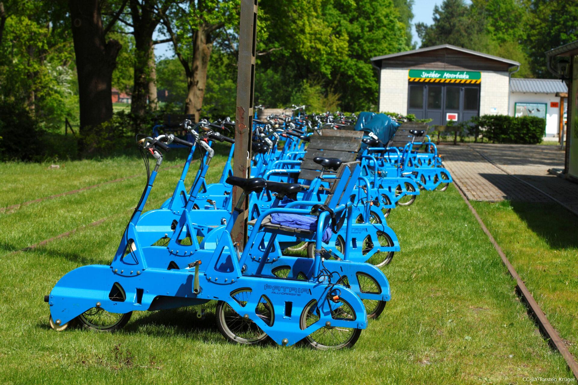 Aufgereihte Draisinen mit Moorbahnbahnhof