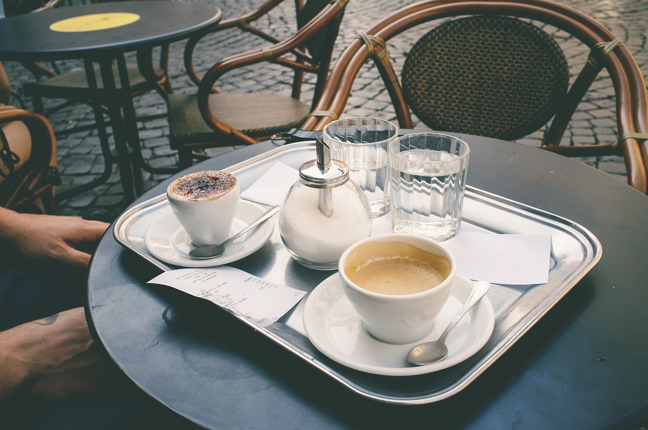 Ein Tablett mit einem Capuccino, einem Kaffee und zwei Gläsern Wasser