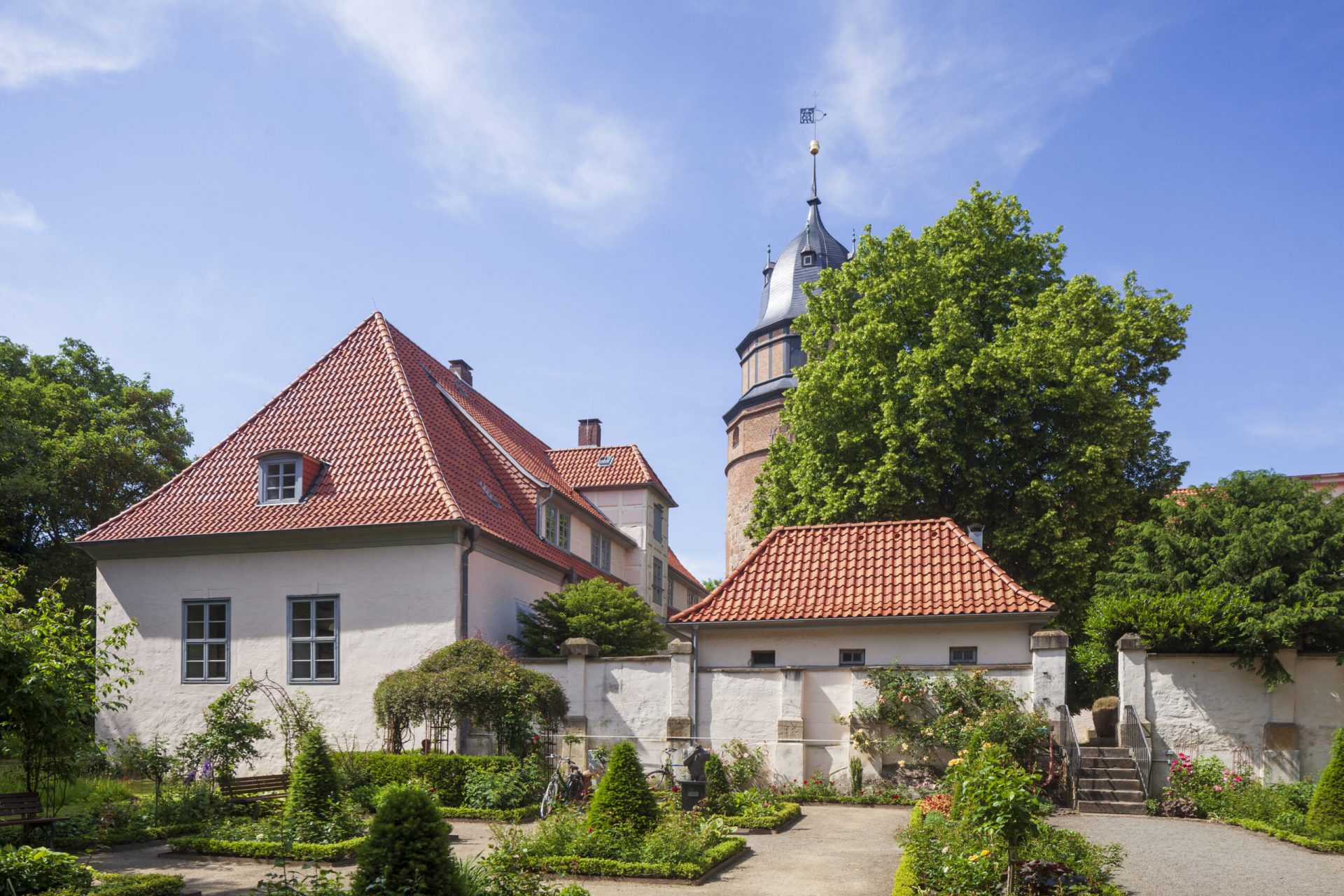 Das Bild zeigt das Diepholzer Schloss mit dem Rosengarten im Vordergrund