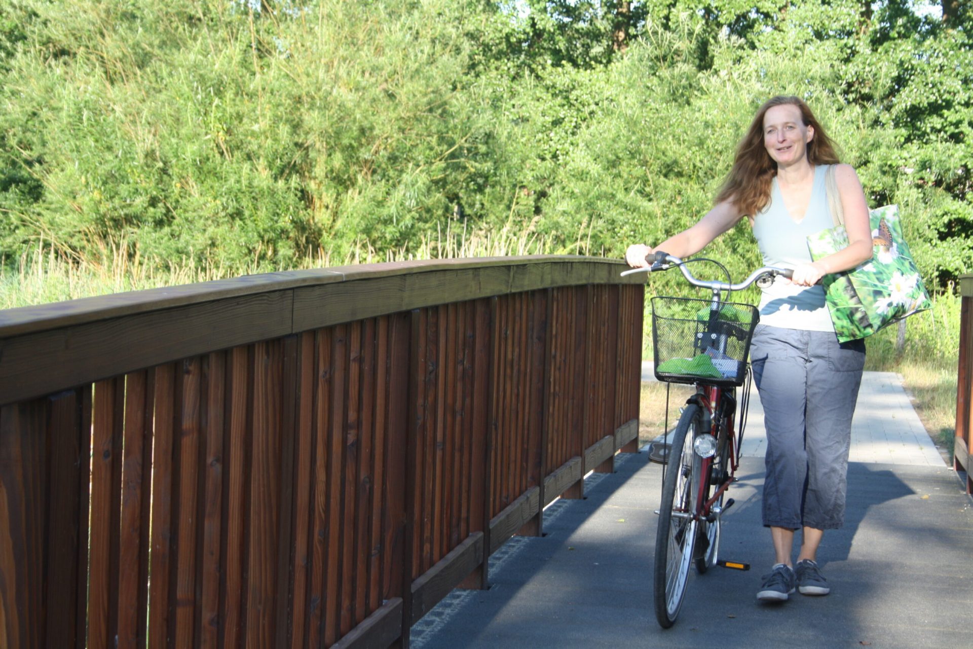 Frau schiebt ihr Fahrrad über die Huntebrücke