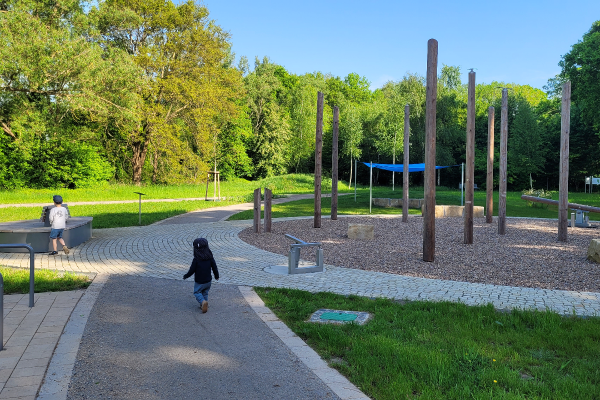 Zwei kleine Jungs laufen auf dem Spielplatz im Kurpark Levern