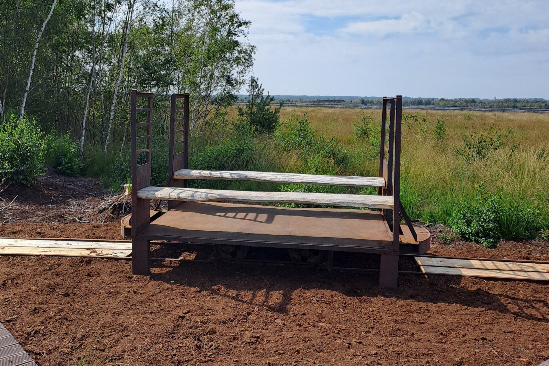 Lore_AschenerMoor Lore mit 2 Sitzbänken aus Holz steht im Aschener Moor