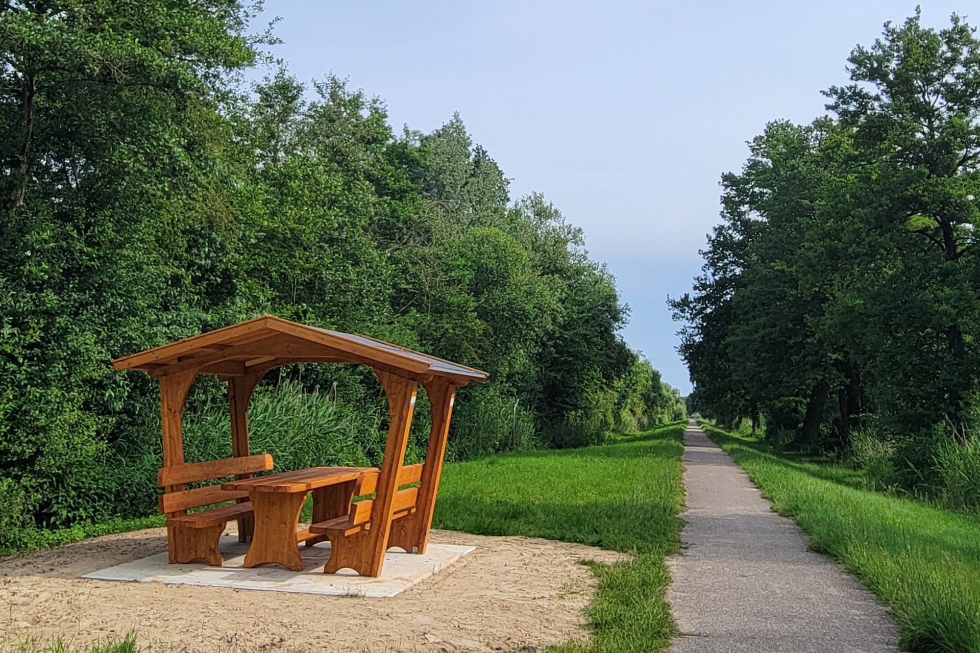 Picknickplatz Netzsegen Überdachter Picknickplatz aus Holz an einem Weg mit Bäumen rechts und links