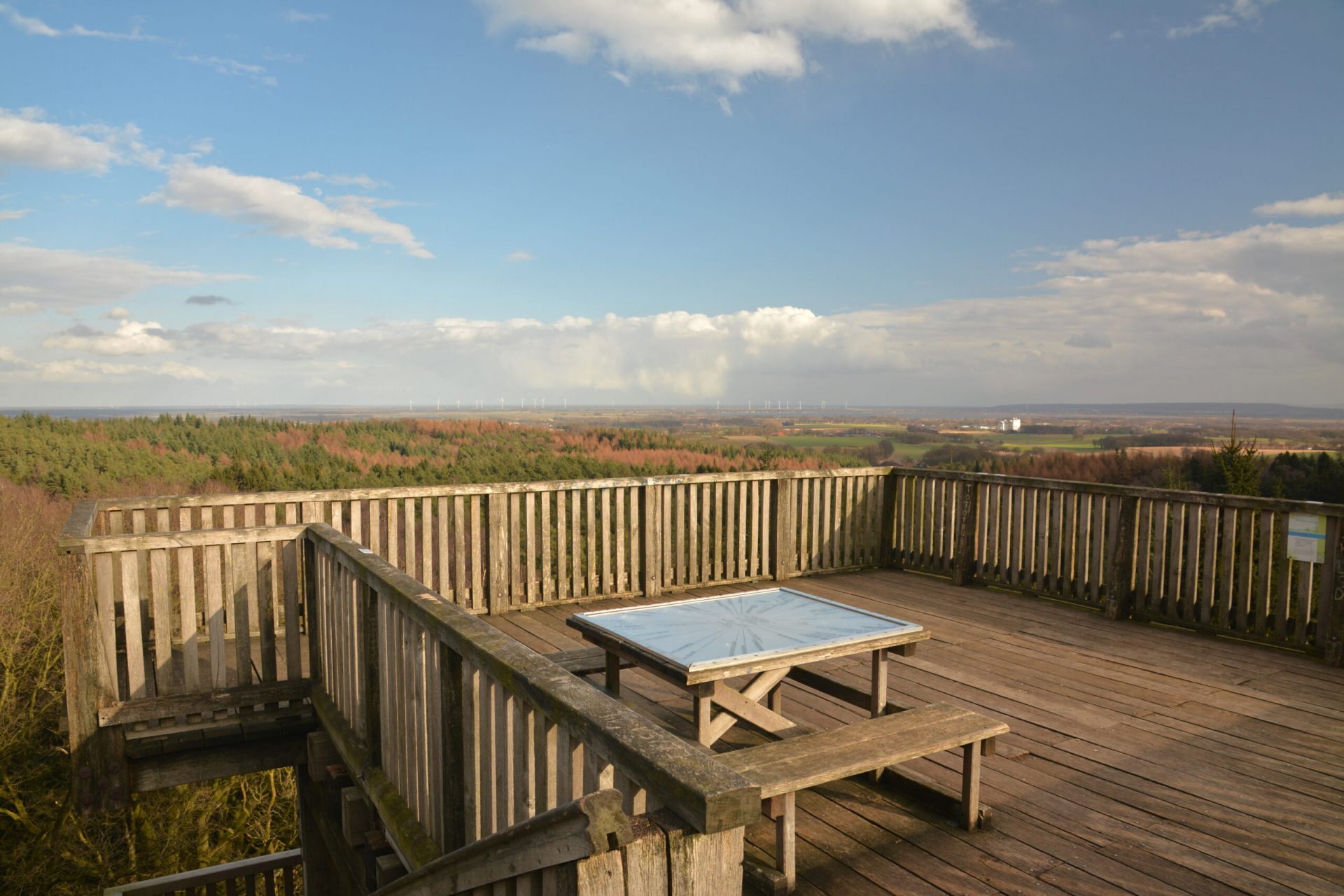 Plattform des hölzernen Aussichtsturms am Mordkuhlenberg mit Tisch und Bänken und Landschaft im Hintergrund
