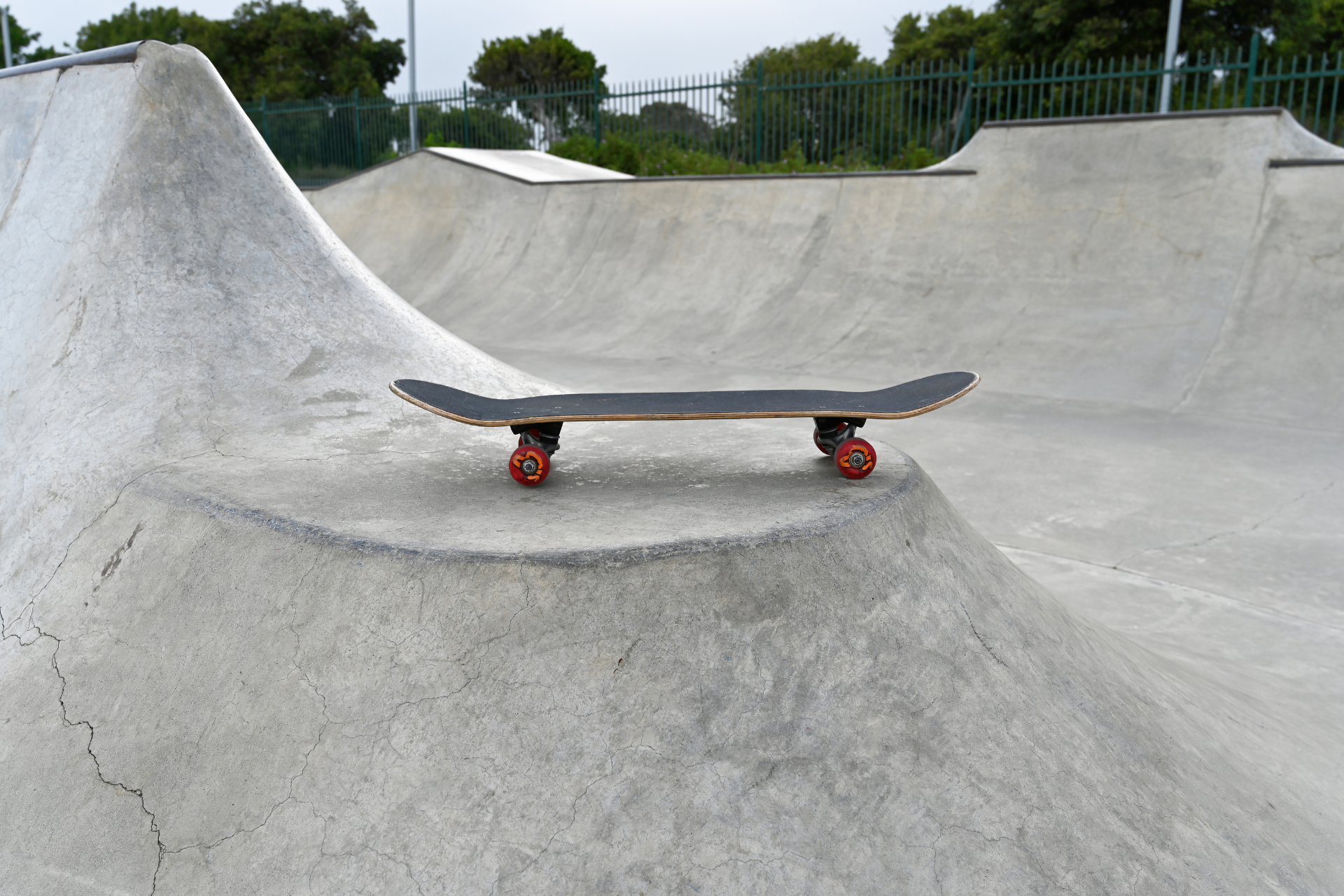 Ein Skateboard steht auf einer menschenleeren Skateanlage